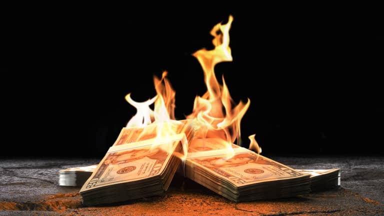 A pile of money being lit on fire