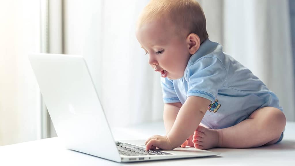 A baby with a laptop, illustrating inexperienced website designers