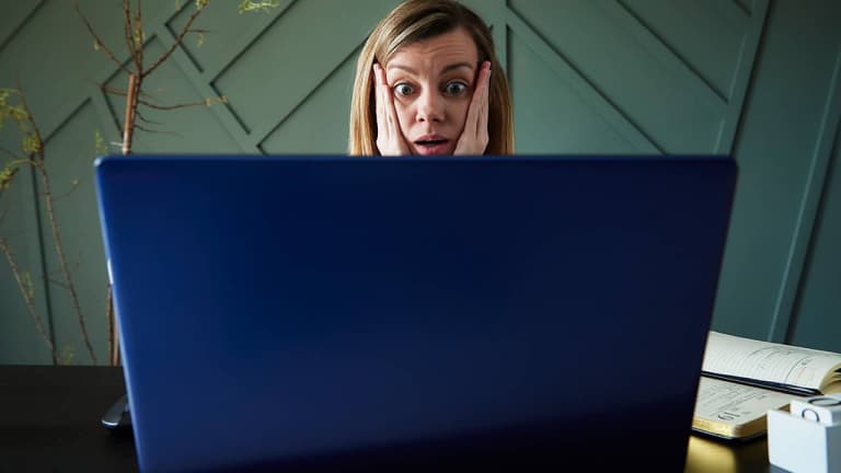 Shocked woman looking at laptop screen