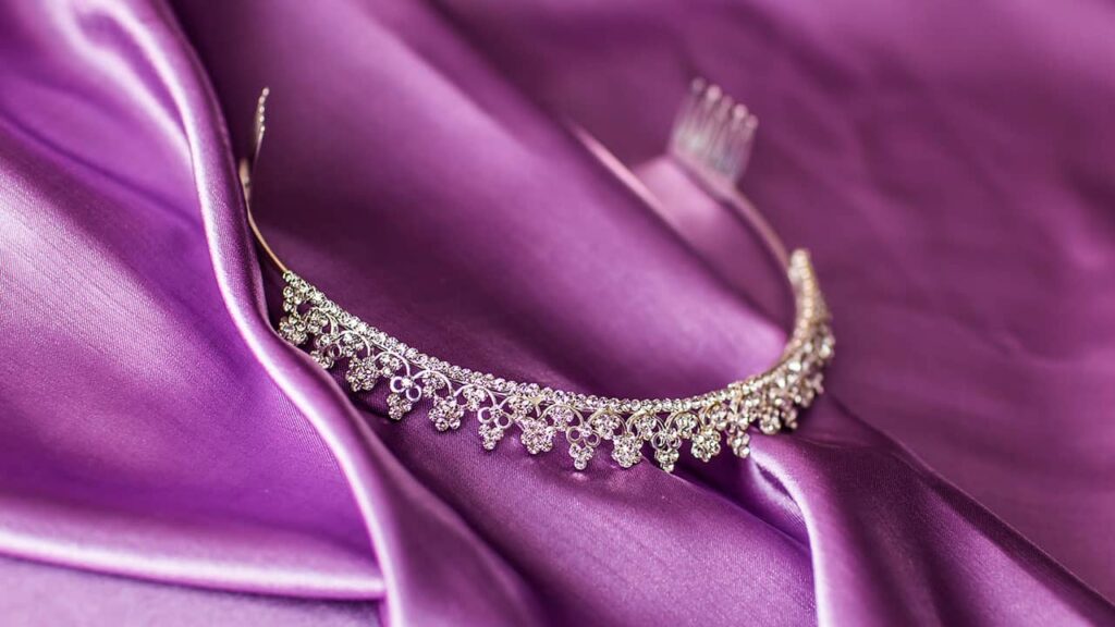 A diamond tiara rests on a smooth purple satin fabric, reflecting the principles of web design psychology.